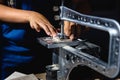 young man cuts a pattern on plywood with an electrical fretsaw