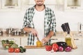 Young man cuts vegetables in the kitchen. Royalty Free Stock Photo