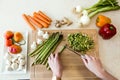 Young man cutting fresh vegetables in kitchen. Royalty Free Stock Photo