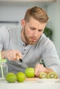 young man cutting fruit in kitchen Royalty Free Stock Photo