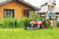 Young man cutting grass in his yard with lawn mower Royalty Free Stock Photo