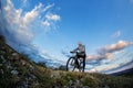 Young man cycling on a rural road through meadow