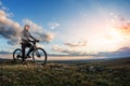 Young man cycling on a rural road through meadow