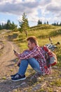 Young man cyclist sits on the edge of a dirt road