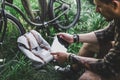 Young Man Cyclist Sits On Summer Meadow Near Bicycle, Holding And Looking At Tablet Recreation Resting Travel Destination Concept Royalty Free Stock Photo