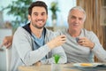 young man and dad having lunch together Royalty Free Stock Photo