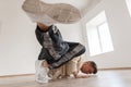 A young man is dancing break dance in a white pullover Royalty Free Stock Photo