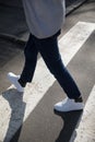 Young man in a dark trousers and sneakers crossing the road Royalty Free Stock Photo