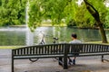 Young man day dreaming on a wooden bench in the park Royalty Free Stock Photo