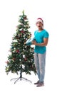 The young man decorating christmas tree isolated on white Royalty Free Stock Photo