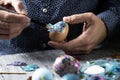 Young man decorating homemade easter eggs