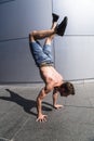 Young man in denim shorts breakdancing outdoor