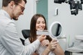 Young man dentist in white coat show veneers enamel color palette for beautiful patient woman Royalty Free Stock Photo