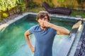 Young man with disgust on his face pinches nose, something stinks, very bad smell in swimming pool because of pool Royalty Free Stock Photo