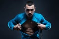 Young man displaying his abdominal muscles holding open his stylish blue shirt Royalty Free Stock Photo