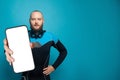 Young man diver holding smartphone with empty white screen display for new Application on blue studio wall background. Royalty Free Stock Photo