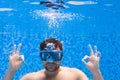 Young man in diving mask swimming the front crawl in a pool, taken under water Royalty Free Stock Photo