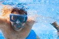 Young man in diving mask swimming the front crawl in a pool, taken under water Royalty Free Stock Photo