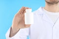 Young man doctor holds bottle of pills on blue background Royalty Free Stock Photo