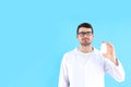 Young man doctor holds bottle of pills on blue background Royalty Free Stock Photo