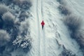 A young man does sports on a snowy path, aerial view