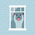Young man does a workout by the open window. Boy holds dumbbells in his hands