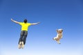 Young man and dog jumping in the sky Royalty Free Stock Photo