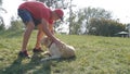 Young man and dog playing outdoor at nature. Labrador or golden retriever and his male owner spend time together at the Royalty Free Stock Photo