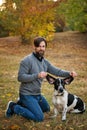 Young man with dog walks in autumn park. Royalty Free Stock Photo