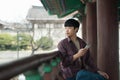 Young man doing a backpacking trip in a Korean traditional house. Use your smartphone Royalty Free Stock Photo