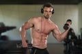 Young Man Doing Exercise For Biceps With Dumbbells Royalty Free Stock Photo