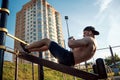 Young man doing exercise on the press on the sports field, athlete, outdoor training in the city copy space Royalty Free Stock Photo