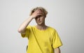 Young man doing facepalm gesture. Portrait of ashamed abashed man in yellow t-shirt covering his face with hand on a