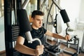 Young man doing fitness exercises on home gym chest press machine.Making an effort and training for fit toned summer body shape.
