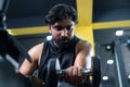 young man doing forearms workout using dumbbells at gym - cocept of fitness training, bodybuilding and healthy lifestyle