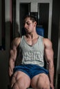 Young man doing heavy weight exercise for legs on machine leg extensions Royalty Free Stock Photo
