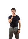 Young man doing hush sign with finger over his mouth, looking at camera Royalty Free Stock Photo