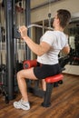 Young man doing lats pull-down workout in gym Royalty Free Stock Photo