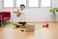 Young man doing plank exercise with online tutorial at home, free space