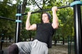 Young man doing pull ups on horizontal bar outdoors, workout, sp Royalty Free Stock Photo