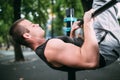 Young man doing pull ups on horizontal bar outdoors, workout, sp Royalty Free Stock Photo