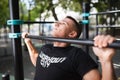 Young man doing pull ups on horizontal bar outdoors, workout, sport concept Royalty Free Stock Photo