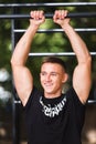 Young man doing pull ups on horizontal bar outdoors, workout, sport concept Royalty Free Stock Photo