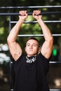 Young man doing pull ups on horizontal bar outdoors, workout, sport concept Royalty Free Stock Photo