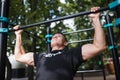 Young man doing pull ups on horizontal bar outdoors, workout, sport concept Royalty Free Stock Photo