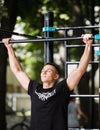 Young man doing pull ups on horizontal bar outdoors, workout, sport concept Royalty Free Stock Photo