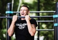 Young man doing pull ups on horizontal bar outdoors, workout, sport concept Royalty Free Stock Photo