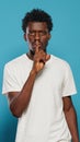 Young man doing silence gesture with finger on mouth Royalty Free Stock Photo