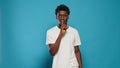 Young man doing silence gesture with finger on mouth Royalty Free Stock Photo