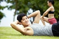 Young man doing sit-ups in park Royalty Free Stock Photo
